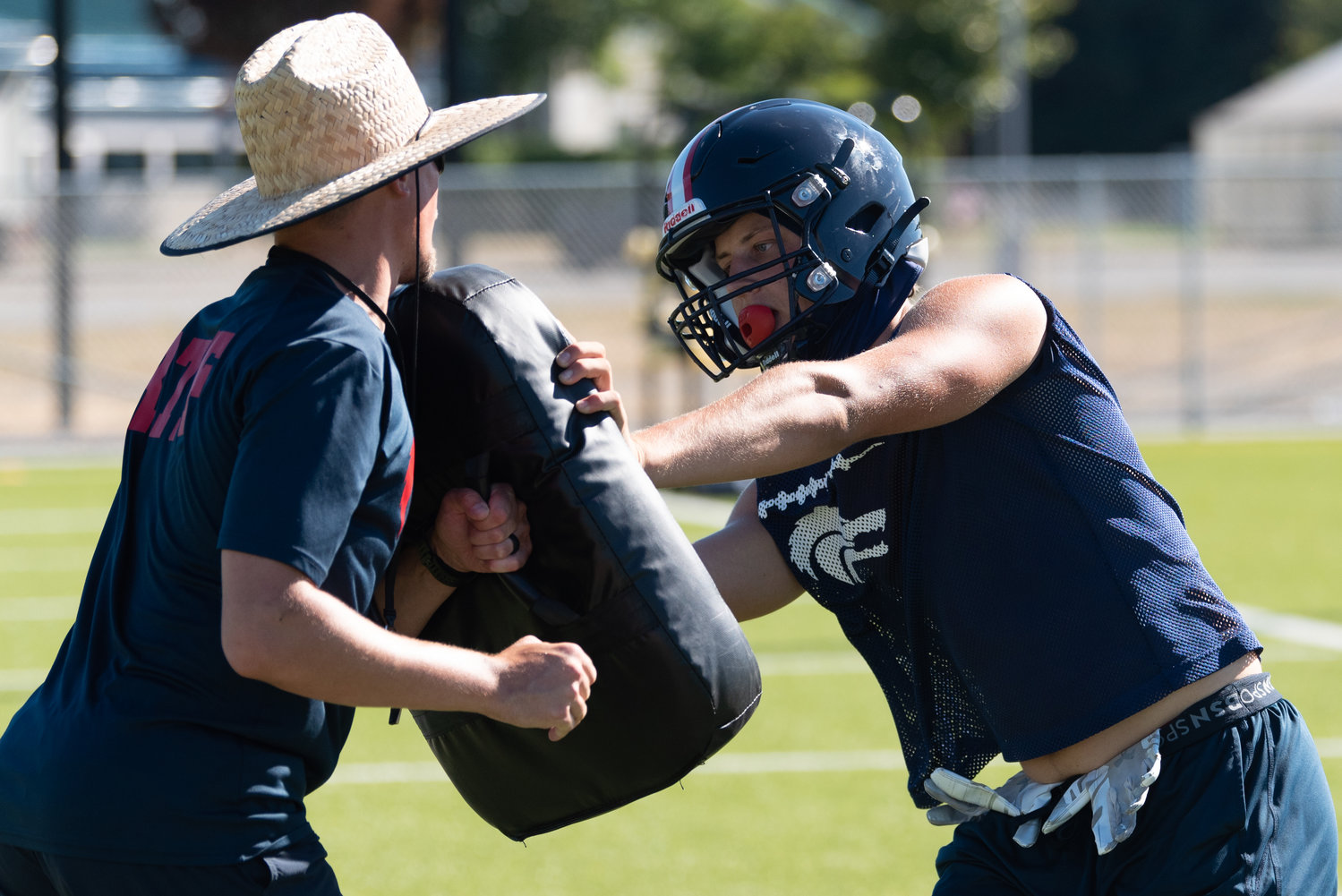Black Hills coach Garrett Baldwin (left) works through a drill with a player during an Aug. 22 practice.